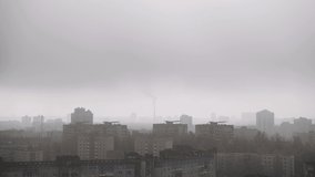 White thick smog over the roofs of buildings in the city on autumn day, aerial view. Smoke rises from the factory chimney. Black crow flies in a foggy gray urban area with cheap apartments. - Powered by Shutterstock - Get 15% off with code: PIKWIZARD15