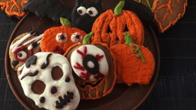 A woman's hand lays out gingerbread for Halloween on a clay plate. Ginger cookies in colored sugar glaze - Powered by Shutterstock - Get 15% off with code: PIKWIZARD15