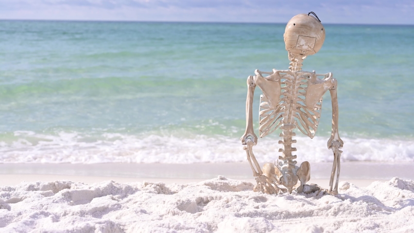 skeleton on bench enjoying white sand beach Royalty-Free Stock Footage #1093770551