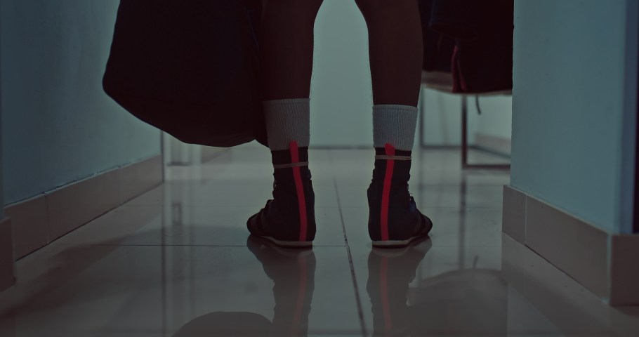 sportsman in boxing shoes is walking in corridor of sportive center, closeup of feet, 4K, Prores