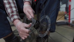 Bicycle mechanic fixing cycle wheel in repair shop. Velocipede service. Repairer male bike shop engineer fix bicycle wheel in workshop. Technician fixes bike parts. Handyman at work in the workplace - Powered by Shutterstock - Get 15% off with code: PIKWIZARD15