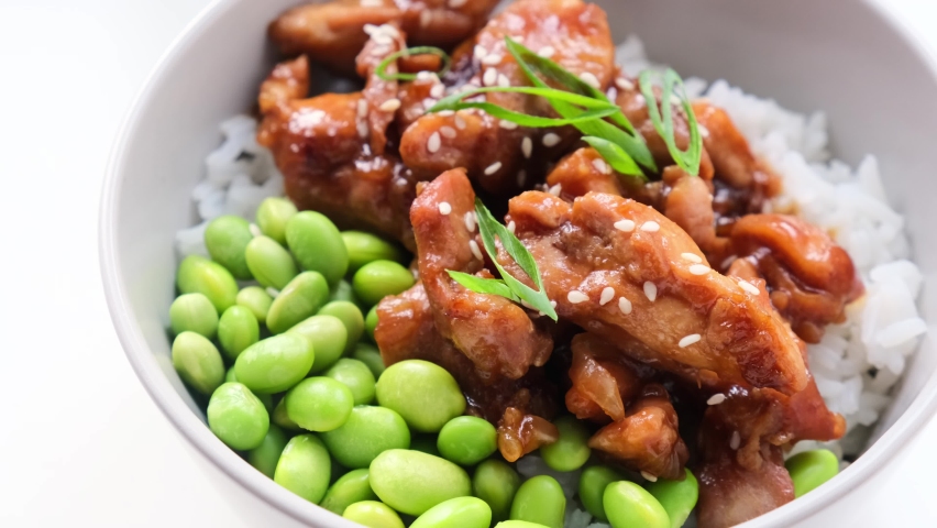 Teriyaki chicken with rice and edamame beans in gray bowl, close-up. Japanese cuisine. Royalty-Free Stock Footage #1093781279