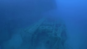 Scuba divers swims on the Shipwreck. Wreck diving. Mediterranean sea, Cyprus. Maritime disasters. Underwater 4K video filming Shot Of Sunken Ship. World tragedies under water undersea.
