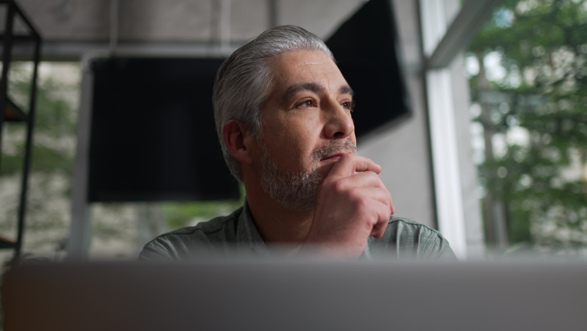 Thoughtful older executive staring out window. Pensive middle aged person contemplating decision. Senior businessman in meditation Royalty-Free Stock Footage #1093784957