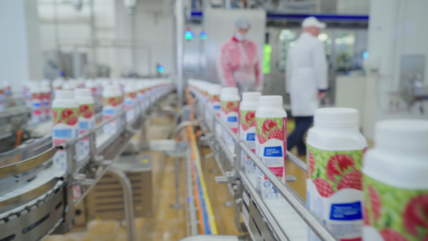 Close Up Of Dairy Food Production Conveyor Line Moving Milk Bottles Through Factory. Industrial Milk Production Automatic Conveyor Line. Bottled Milk Production Conveyor Line Equipment Royalty-Free Stock Footage #1093787805