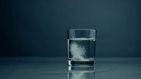 Effervescent tablet falling glass with water closeup. Dropped medicine bubbling in pure mineral liquid at dark background. Acid fizzy pill dissolving in cup. Painkiller hangover treatment concept. - Powered by Shutterstock - Get 15% off with code: PIKWIZARD15