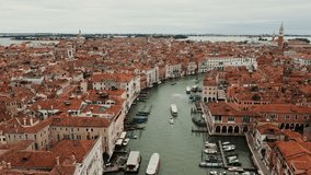 Drone footage of a beautiful panoramic view of Venice with traditional orange houses on either side of the Grand Canal. Italy, city on the water