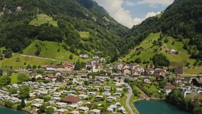 A modern cottage village at the foot of the Alps, a bird's-eye view. Drone video, view of the town on the shore of a picturesque lake in Switzerland