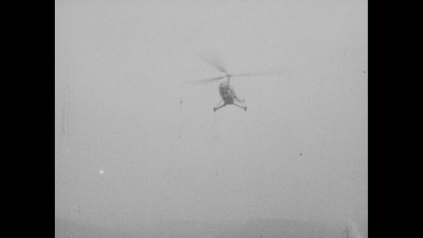 1950s: Sikorsky s-51 helicopter comes in to land at airport. Sikorsky helicopter takes off at night.