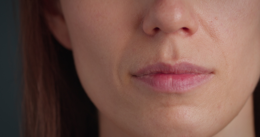 Woman gesturing keep secret and looking at the camera, closeup