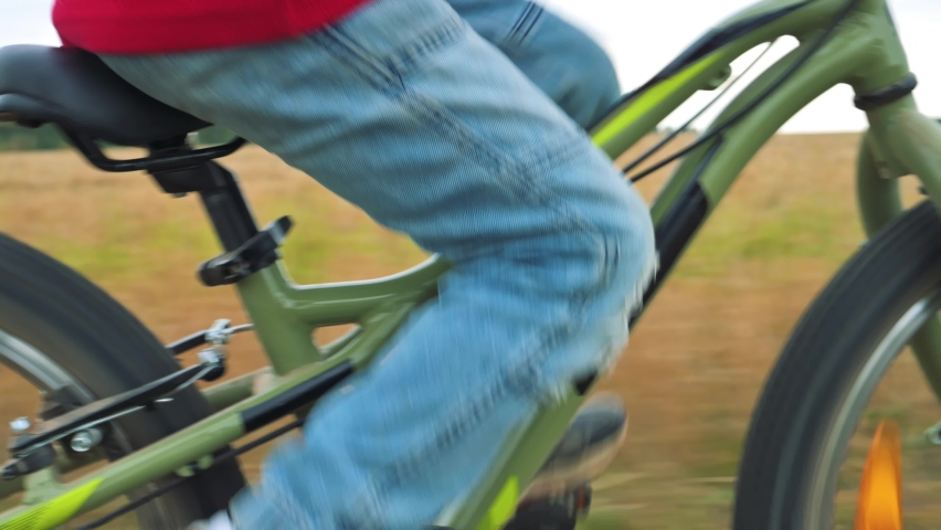 The boy riding his bicycle neer the field. 4k video footage 