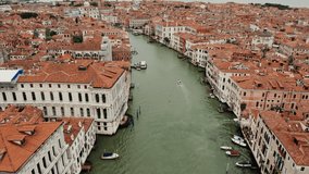 Top view of the Grand Canal with empty gondolas tied to the pier. Traditional houses on both sides of the canal, drone footage on a sunny day. Venice, Italy