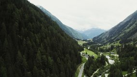 Panoramic video shooting from a drone, a beautiful view of the village, located in a lowland between the Alpine mountains. Austria, mountain landscape aerial view