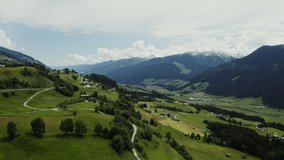 Panoramic view of the picturesque mountain valley with cottage houses in the lowland, located at a distance from each other. Bird's eye view video, Alps, Austria