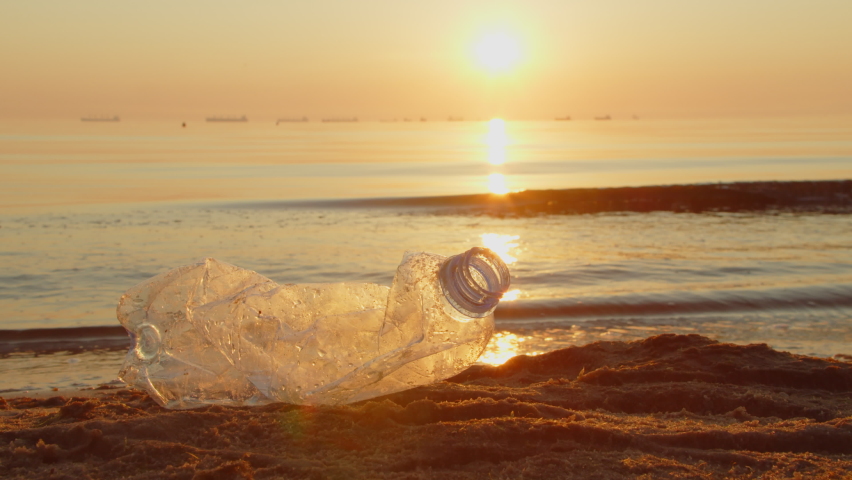 Close-up, a volunteer collects plastic garbage on the beach with gloves and puts it in a garbage bag. Volunteers clean the beach. Cleaning up trash on the beach.  Royalty-Free Stock Footage #1093831943