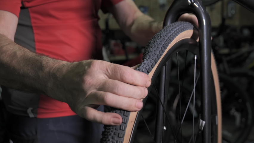 Bicycle mechanic pumping air into bike tire. Repair bike in cycling workshop. Bike maintenance, sport shop concept. Slow motion