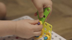 close-up baby child hands screwing nut and screw-bolt in toy constructor game. selective focus on child's fingers screw nuts, bolt, fixing building elements, designing construction. educational - Powered by Shutterstock - Get 15% off with code: PIKWIZARD15