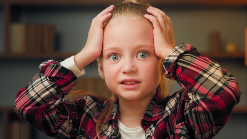 Scared young little girl shocked confused child feeling bullied abandoned alone caucasian blonde female kid preschool toddler six years old stressed hold head by hands fearful frightened nervous | Shutterstock HD Video #1093848385