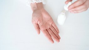 Hand of woman cleaning her hand With alcohol gel liquid from clear bottle on white background isolated. Asian women clean hand . High quality 4k footage