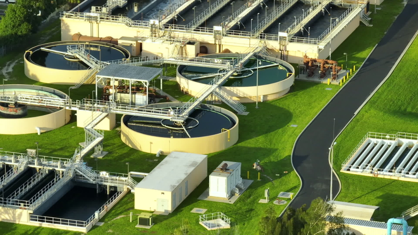 Aerial view of modern water cleaning facility at urban wastewater treatment plant. Purification process of removing undesirable chemicals, suspended solids and gases from contaminated liquid Royalty-Free Stock Footage #1093849539