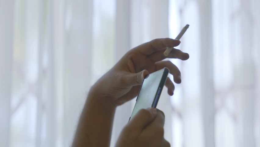 Man Smoking Cigarette Using While Using A Mobile Phone | Shutterstock HD Video #1093854705