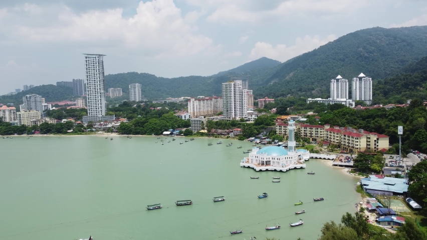 Aerial drone footage of Penang coastline near George Town with the famous floating mosque in Malaysia. 