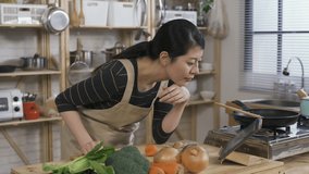 asian new wife leaning on the kitchen table and using a touchpad to learn cooking by watching online culinary tutorials in the kitchen at home during daytime. - Powered by Shutterstock - Get 15% off with code: PIKWIZARD15