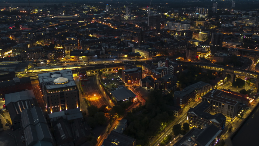 Establishing Aerial View Shot of Newcastle upon Tyne UK, Tyne and Wear, England United Kingdom looking down deep in at night evening, cinematic light