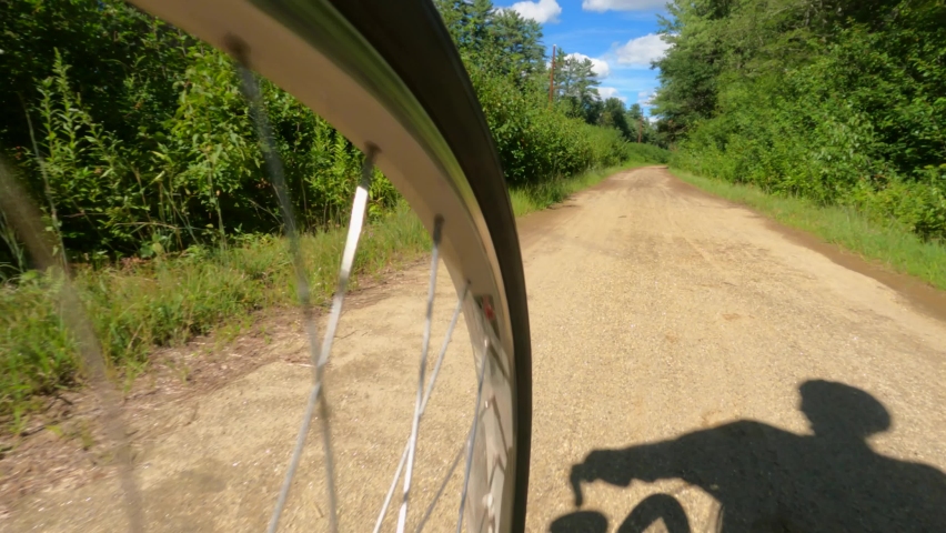 Slow motion low angle clip of a rider on a bicycle on rails to trails path