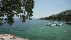 Trees and coastline of Adriatic Sea with Lovran in the background, Lovran, Eastern Istria, Croatia, Europe