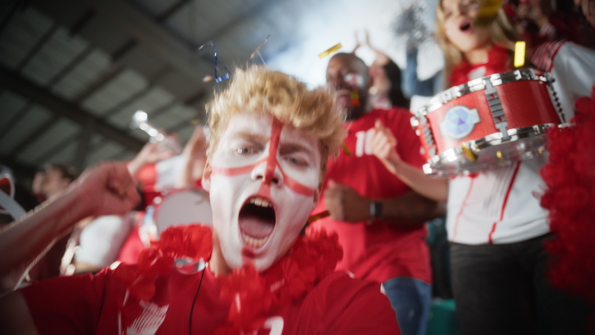 Stadium Sport Event: Selfie Portrait of Man with Painted Face Holding and Shooting Himself on Smartphone, Cheers for Red Team to Win, Screaming, Celebrating Championship Victory with Crowd