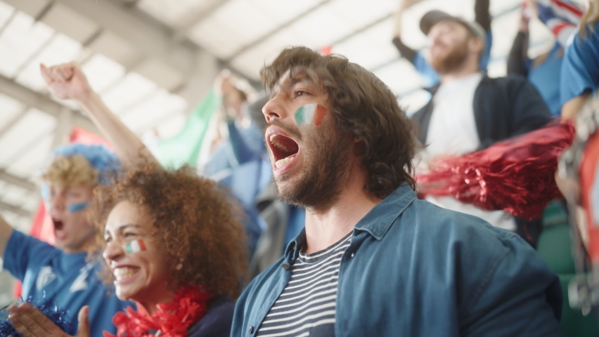 Sport Stadium Soccer Match: Portrait of Excited Hispanic Couple with Italian Flag Painted Faces Cheering Team to Win, Scream, Beg, Laugh. Crowd Celebrate Goal, Championship Victory. Slow Motion Royalty-Free Stock Footage #1093867149