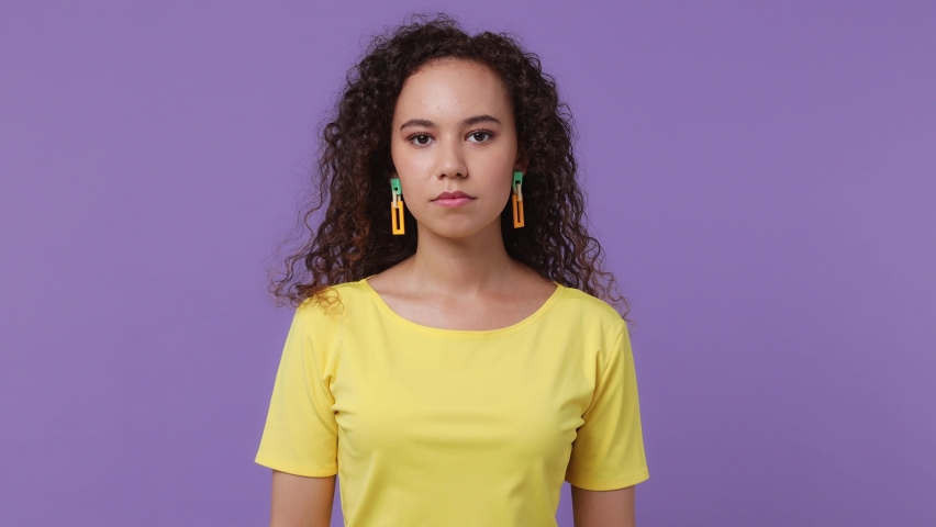 Young sad serious strict severe woman of African American ethnicity wear yellow t-shirt say no hold palm folded crossed hands in stop gesture isolated on plain pastel light purple background studio Royalty-Free Stock Footage #1093871073