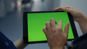 Close-up of a tablet with a green screen in the hands of two doctors - Powered by Shutterstock - Get 15% off with code: PIKWIZARD15