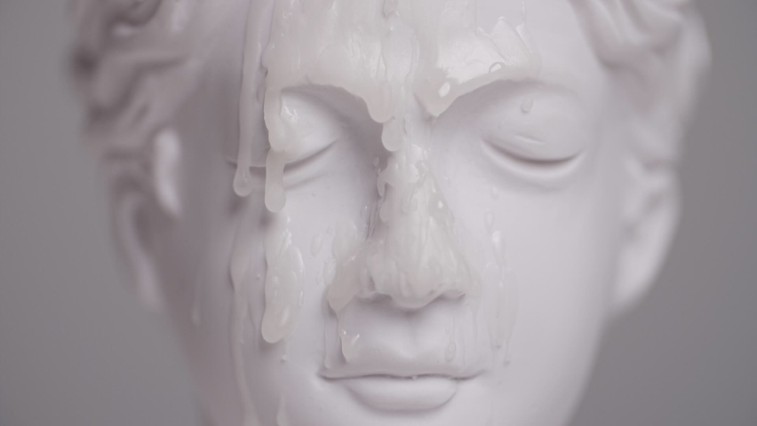drops of wax falling on the face of an antique statue