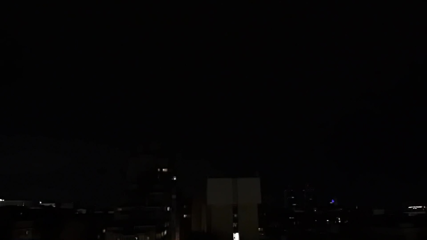 Lightning and thunder over the city at night, glaring and spectacular lightning, thunderstorms from window in near vintage skyscraper