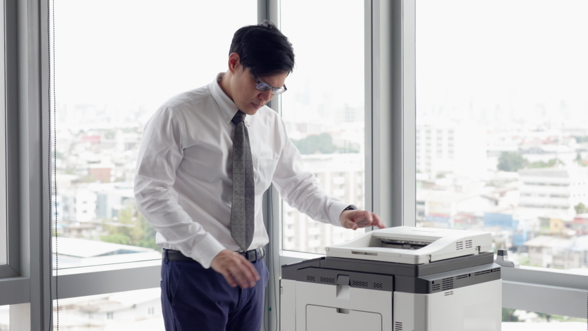 Overload office worker. Alone frustrated asian office worker  rushing to work but copy machine error at the office. Royalty-Free Stock Footage #1093887905