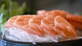 4k video of the plate full of salmon sashimi, raw fish Japanese style food. Slowly using chopsticks