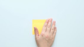 A hand sticks a yellow piece of paper for notes on a white surface - Powered by Shutterstock - Get 15% off with code: PIKWIZARD15