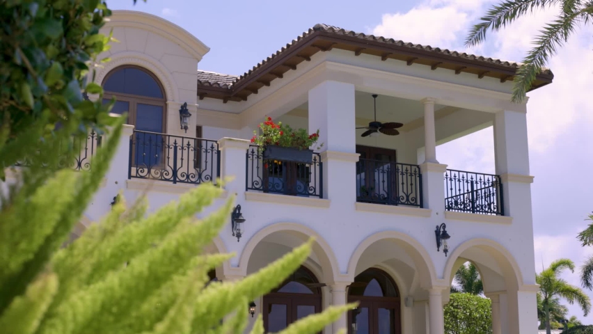 shot of a beautiful balcony of a mediterranean mansion with roses and flowers, sunny day, blue sky, luxury mansion, real state, miami florida. Royalty-Free Stock Footage #1093905933