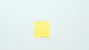 A hand sticks a second yellow piece of paper for notes on a white surface - Powered by Shutterstock - Get 15% off with code: PIKWIZARD15