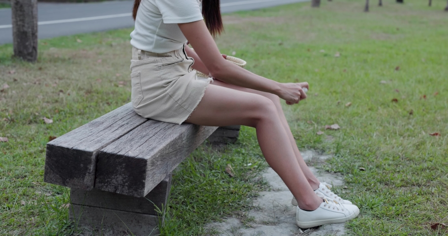 Woman use insect repellent at park