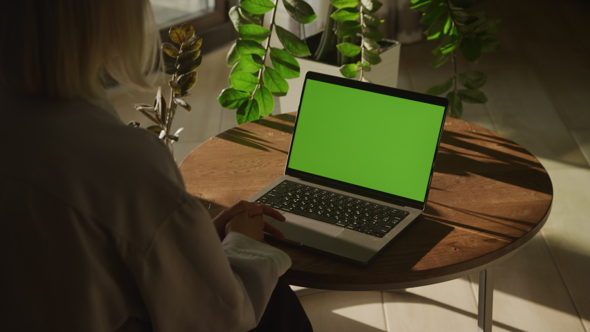 Handheld shot of an unrecognisable caucasian woman watching a laptop computer with green screen | Shutterstock HD Video #1093908735
