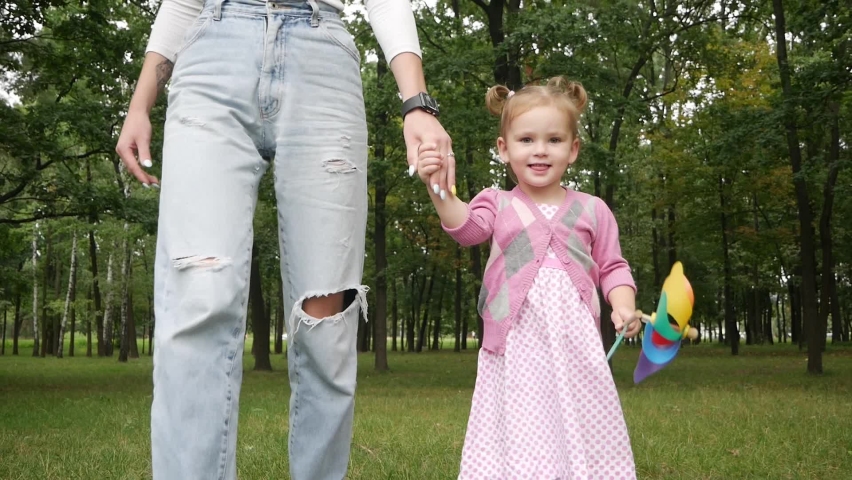 Happy young mother with her little daughter in summer park