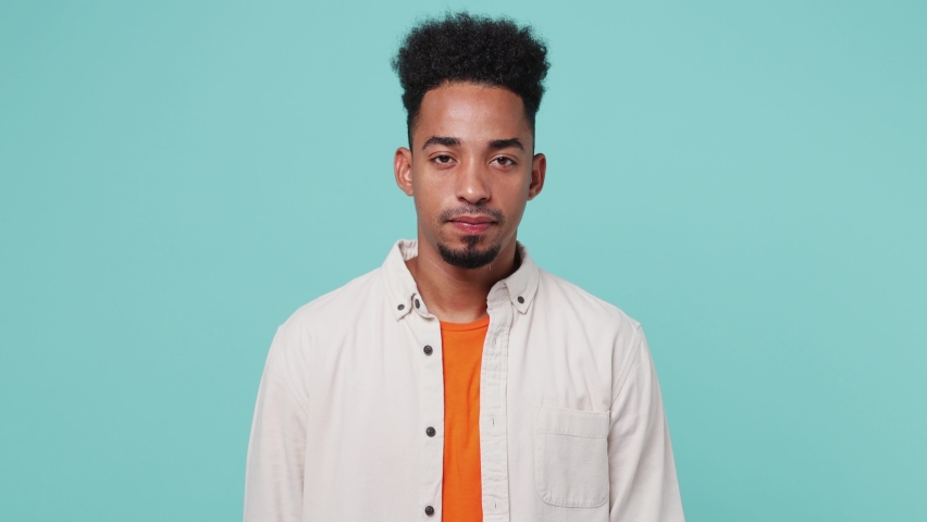 Young sad serious strict severe man of African American ethnicity 20s he wear shirt t-shirt say no hold palm folded crossed hands in stop gesture isolated on plain pastel light blue cyan background Royalty-Free Stock Footage #1093912819