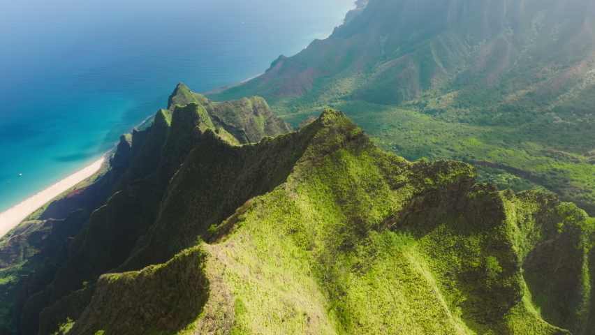 Breathtaking aerial view dramatic mountains, blue ocean on Napali Coast Kauai island Hawaii USA. Beautiful nature drone flying over green jungle mountain peaks revealing tropical beach on Na Pali park | Shutterstock HD Video #1093913527