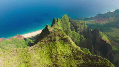 Breathtaking aerial view dramatic mountains, blue ocean on Napali Coast Kauai island Hawaii USA. Beautiful nature drone flying over green jungle mountain peaks revealing tropical beach on Na Pali park - Βίντεο στοκ