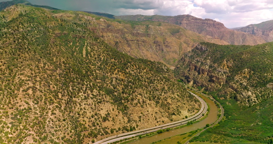Excellent panorama of beautiful mountains in Colorado, USA. Highways and narrow river twirling between the mountains. View from above.