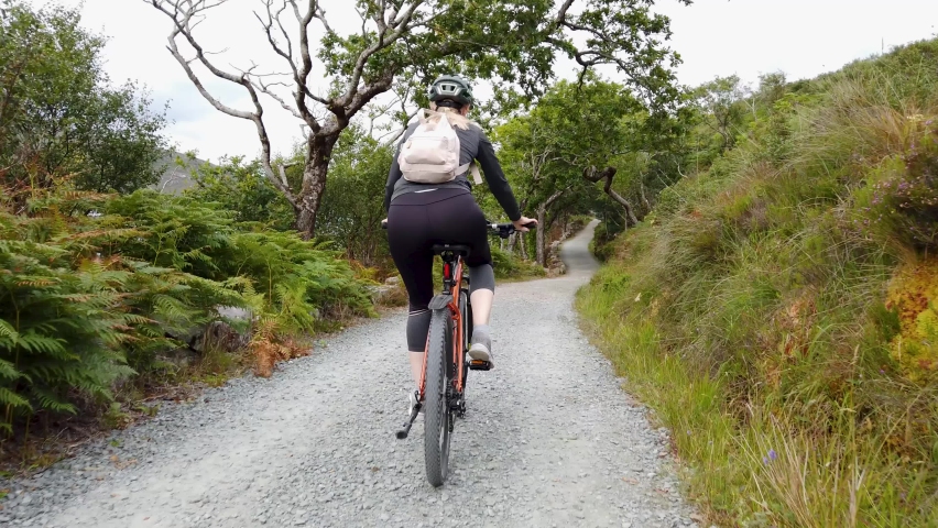 Beautiful lady cycling her mountain bike in County Donegal, Ireland Royalty-Free Stock Footage #1093924825