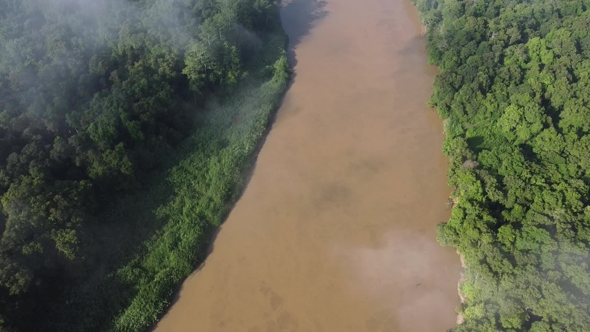 Clouds and mist over Kinabatang River in Borneo, drone tilt-up reveal shot. Remote and dense forest.  Royalty-Free Stock Footage #1093925733